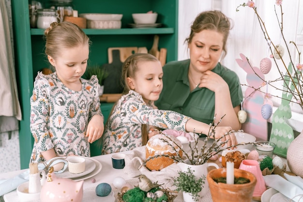 Zdjęcie Święta wielkanocne w sezonie wiosennym szczęśliwa rodzina szczere małe dzieci siostry dziewczyny razem matka bawi się w domu dekorowanie stołu na lunch lub kolację tradycyjne jedzenie świąteczny wystrój domu