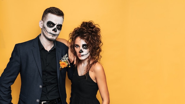 Święto Halloween. Studio strzał młodej pary w świątecznych kostiumach na Halloween i makijażu na twarzy. Miejsce na Twój tekst, reklamę.