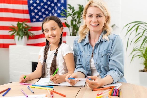 Święto patriotyczne. Szczęśliwa rodzina, matka i córka dziecko dziewczynka z amerykańską flagą w domu. USA świętują 4 lipca.