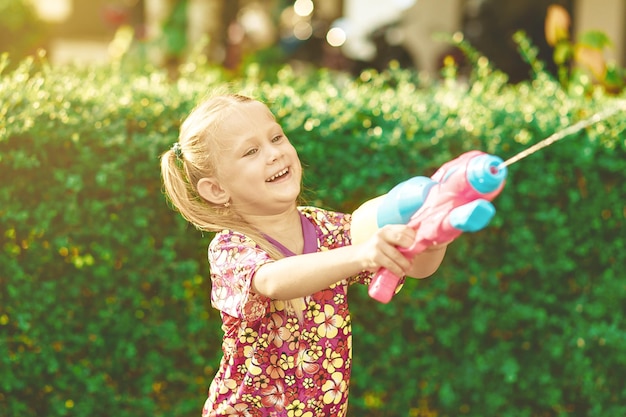 Święto Songkran Zabawna koszula hawajska dla dziewczynki z plastikowym pistoletem na wodę w kolorze. Tajskie wakacje. Tajski Nowy Rok