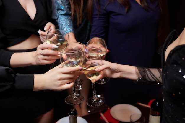 Świętowanie z kieliszkami alkoholu w dłoniach szczęśliwe koleżanki dobrze się bawiące