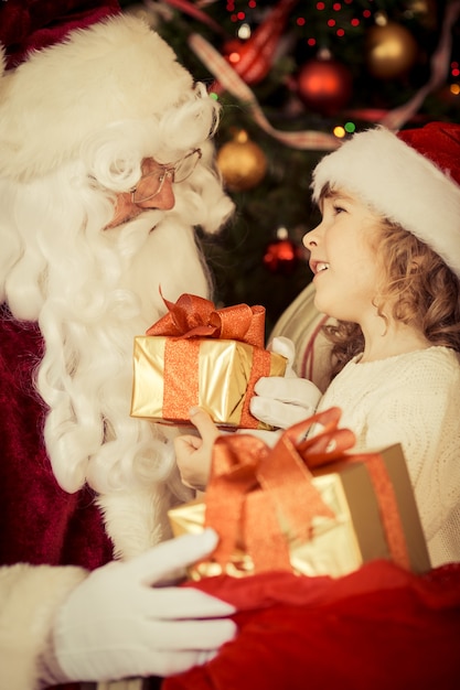 Święty Mikołaj i dziecko w domu. Prezent na Boże Narodzenie. Koncepcja rodzinnych wakacji