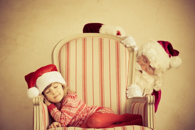 Zdjęcie Święty mikołaj i dziecko w domu. prezent na boże narodzenie. koncepcja rodzinnych wakacji