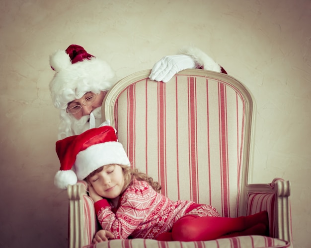 Święty Mikołaj i dziecko w domu. Prezent na Boże Narodzenie. Koncepcja rodzinnych wakacji