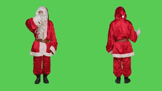 Święty Mikołaj pokazuje kciuki w górę i w dół na tle zielonego ekranu w studiu, ubrany w kostium świętego Nicka. Młoda osoba przedstawiająca głównego bohatera zimy, gestem sympatii i niechęci.