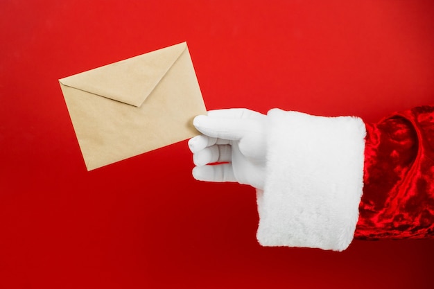 Święty Mikołaj ręka trzyma kopertę rzemieślniczą z listem