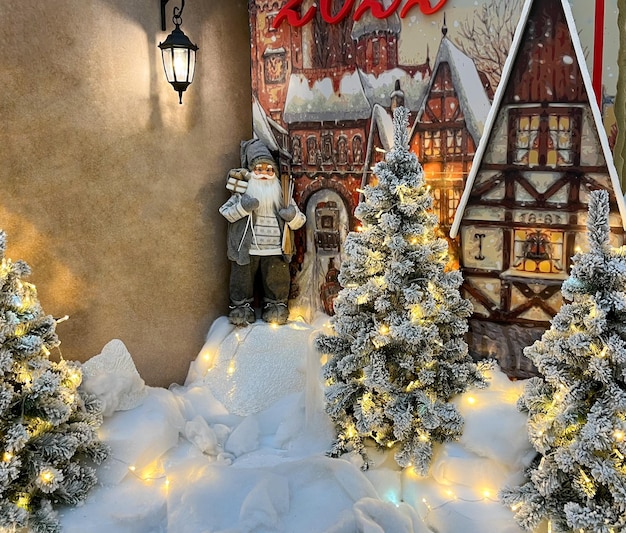 Święty Mikołaj stoi przy choince pod latarnią Boże Narodzenie Święty Mikołaj