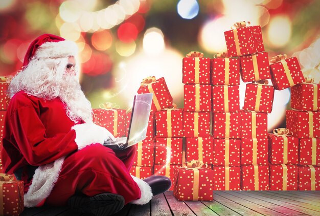 Święty Mikołaj z laptopem i paczkami prezentów