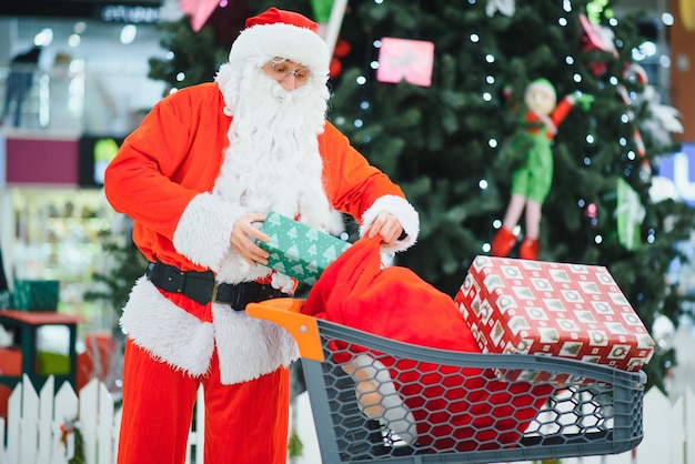 Święty Mikołaj z prezentami w koszyku w centrum handlowym.