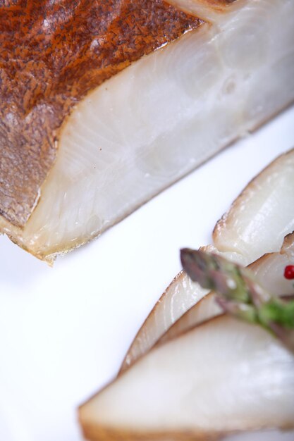 Świeża biała ryba ozdobiona sałatką i przyprawą. Zbliżenie