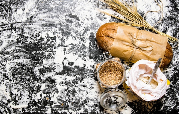 Zdjęcie Świeża ciabatta z workiem mąki i kłosami pszenicy.