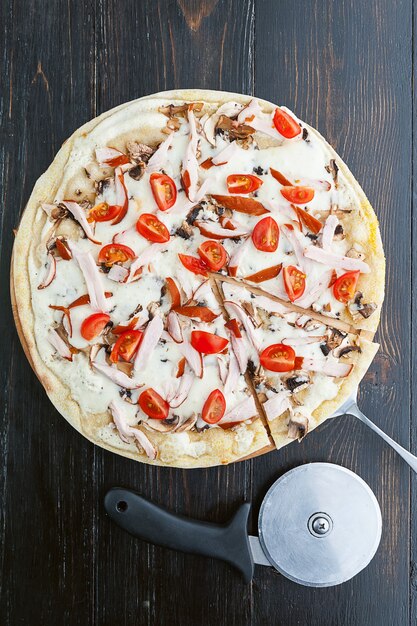 Świeża i pyszna włoska pizza na drewnianym stole i nóż do pizzy