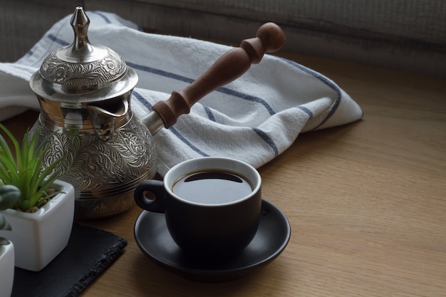 Świeża parzona kawa w cezve, tradycyjny dzbanek do kawy po turecku, filiżanka kawy, soczysty