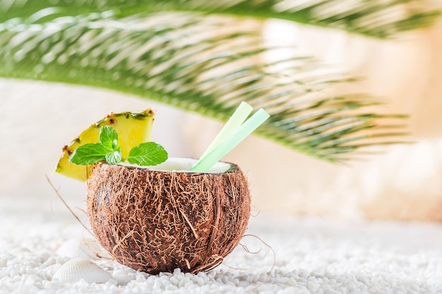 Świeża pinacolada w kokosie na piaszczystej plaży