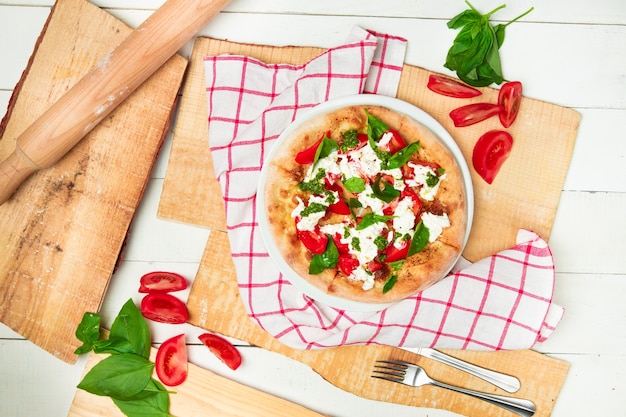 Świeża pizza z ciasta drożdżowego z pieca opalanego drewnem z mozzarellą i bazylią