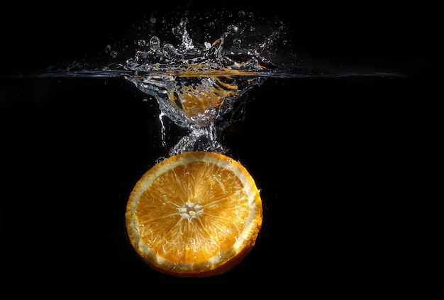 Świeża pomarańcza spadła do wody