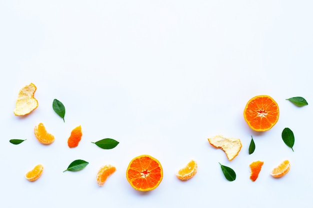 Świeża pomarańczowa cytrus owoc z zielonymi liśćmi na bielu.