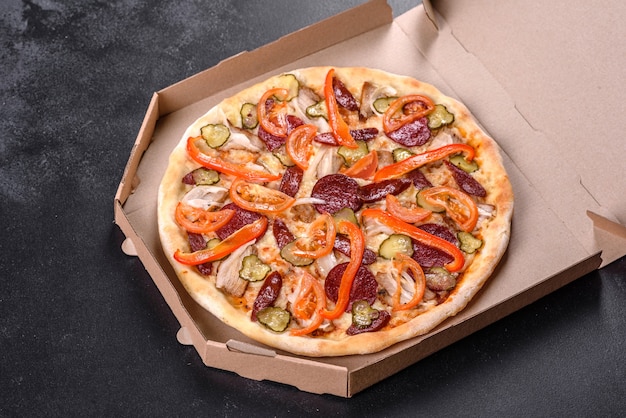 Świeża pyszna pizza pieczona w piecu paleniskowym z kiełbasą, papryką i pomidorami. Kuchnia śródziemnomorska