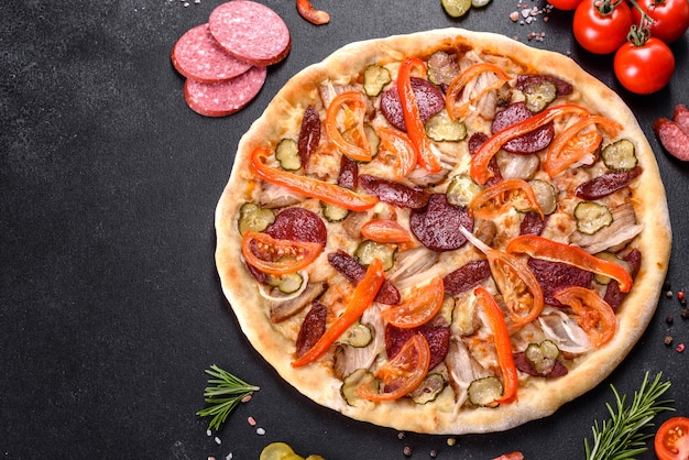 Świeża pyszna pizza pieczona w piecu paleniskowym z kiełbasą, papryką i pomidorami. Kuchnia śródziemnomorska