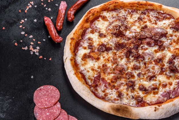 Świeża Pyszna Włoska Pizza Z Czterema Rodzajami Mięsa Na Ciemnym Betonowym Tle. Kuchnia Włoska