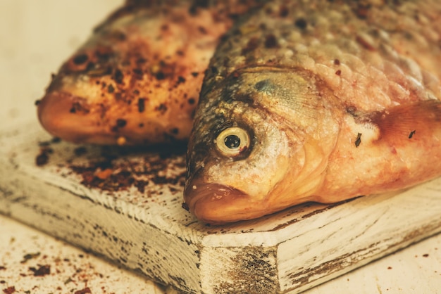 Zdjęcie Świeża ryba. surowa ryba na białym drewnianym stole. ryba na białej drewnianej desce kuchennej na stole
