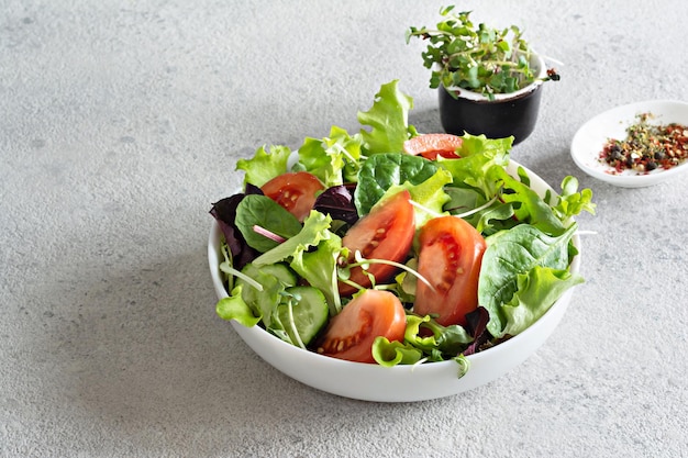 Świeża sałatka ze świeżymi warzywami dojrzałe pomidory sałata ogórkowa i microgreen w misce