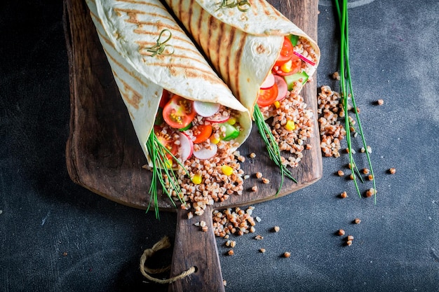 Świeża wegetariańska tortilla z kaszą, pomidorkami koktajlowymi i szczypiorkiem