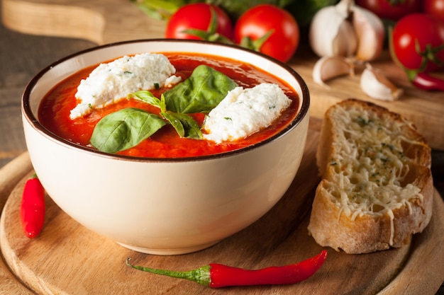 Świeża, zdrowa zupa pomidorowa z bazylią, pieprzem, czosnkiem, pomidorami i chlebem. Hiszpańska zupa gazpacho.