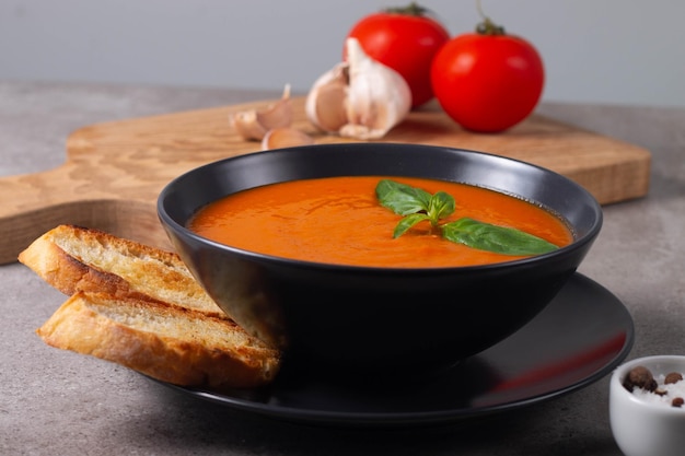 Świeża zdrowa zupa pomidorowa z pomidorami czosnkowymi z bazylią i chlebem na drewnianym tle Hiszpańska zupa gazpacho Zupa z soczewicy i dyni