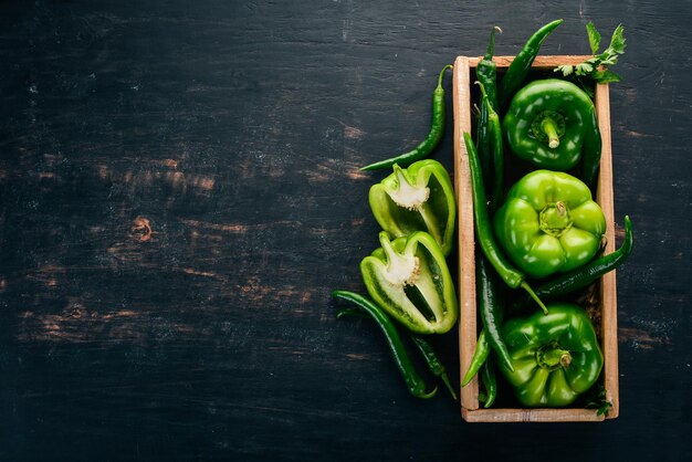 Świeża zielona papryka i papryczka chili w drewnianym pudełku Widok z góry Wolne miejsce na tekst