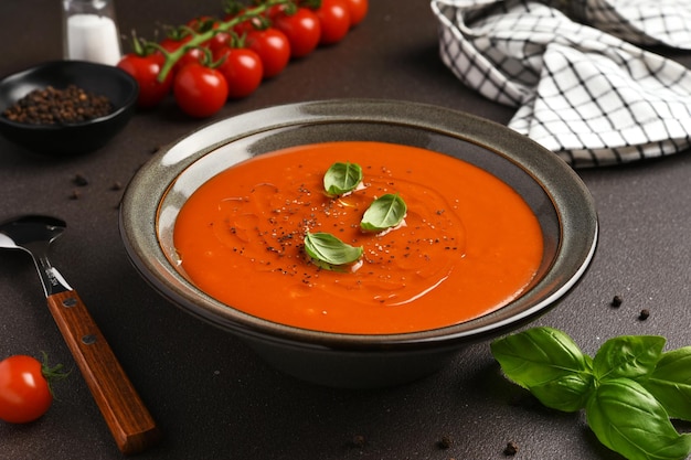 Świeża zupa pomidorowa Gazpacho z bazylią na ciemnym tle