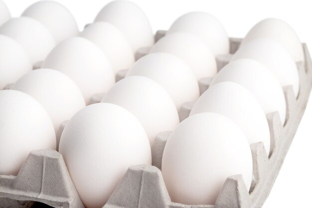 świeże białe jaja kurze w opakowaniu na jasnym tle