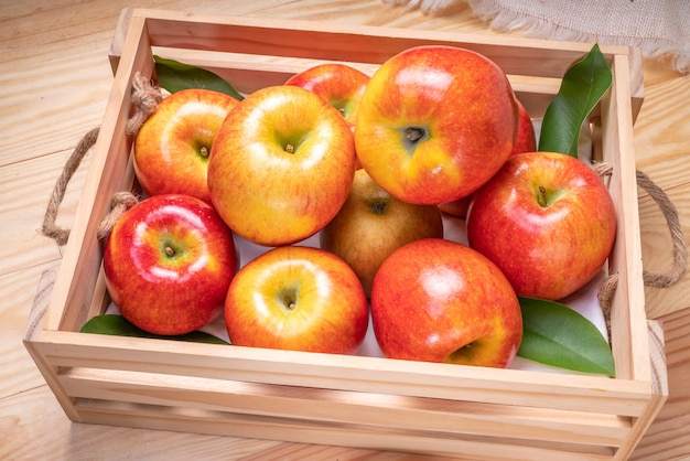 Świeże czerwone jabłko Envy w drewnianym koszu na drewnianym tle Jabłko Envy na drewnianym pudełku
