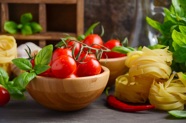 Świeże Czerwone Pomidory Cherry Z Surowego Makaronu, Bazylia, Papryka Chili I Czosnek Na Włoskie Jedzenie.