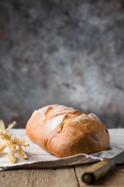 Świeże domowe pieczywo chrupkie na drewnianym tle. Bagietka. Chleb na zakwasie. Przaśny chleb