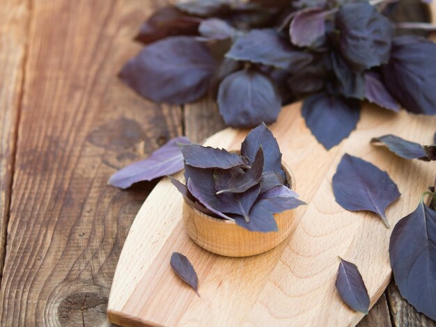 Świeże fioletowe liście bazylii w drewnianej misce