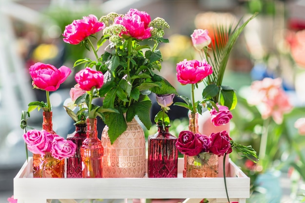 Świeże i ozdobne sztuczne róże w różnych wazonach