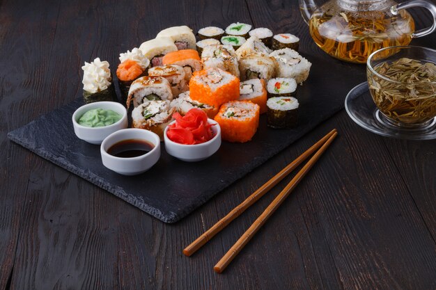 Świeże i smaczne bułki sushi maki i nigiri oraz szklanka zielonej herbaty