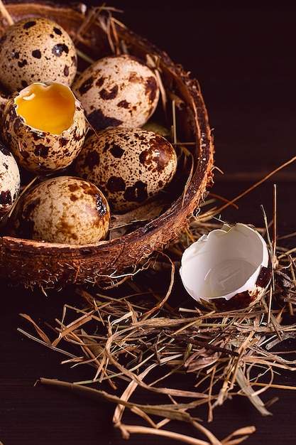 Świeże jajka przepiórcze w talerzu kokosowym na drewnianym brązowym stole widok pionowy bez ludzi