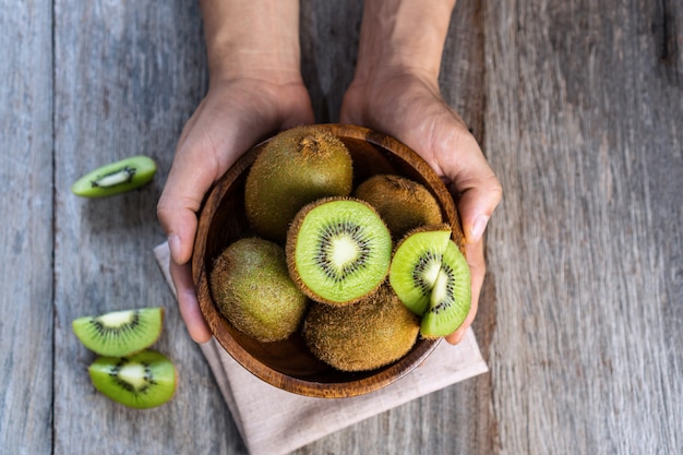 Świeże kiwi w misce na powierzchni drewnianych