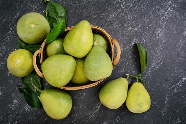 Świeże obrane pomelo pummelo grejpfrutowy shaddock na ciemnym tle w bambusowym koszu Jesień sezonowe owoce widok z góry płaski leżał blat strzał