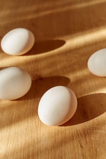 Świeże organiczne białe jajka na drewnianym blacie kuchennym w świetle dziennym.