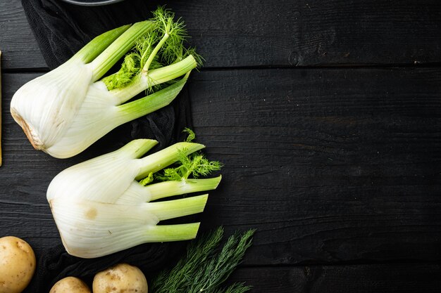 Świeże organiczne fenkuły, na czarnym drewnianym stole, widok z góry z miejscem na tekst