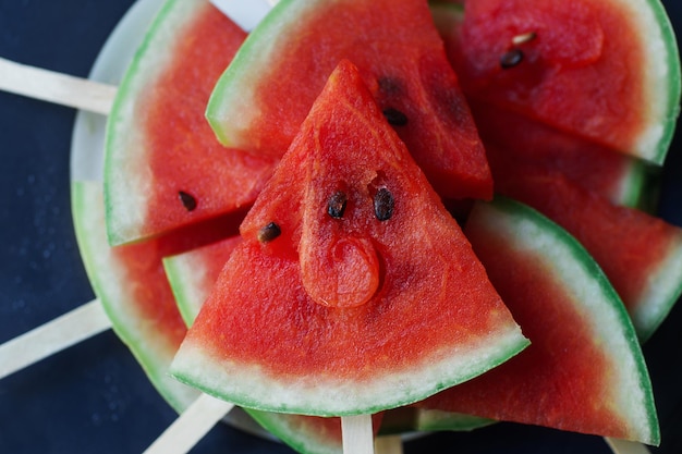 Świeże organiczne popsicles arbuza na ciemnym rustykalnym drewnianym tle