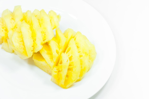Świeże owoce ananasa na białym naczyniu i na białym tle