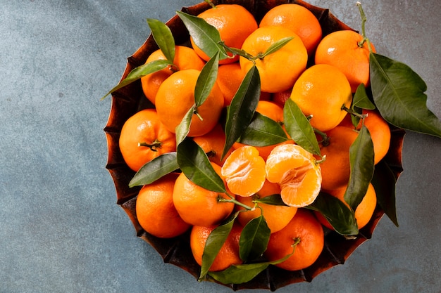 Świeże owoce mandarynki lub mandarynki z liśćmi w drewnianym pudełku widok z góry