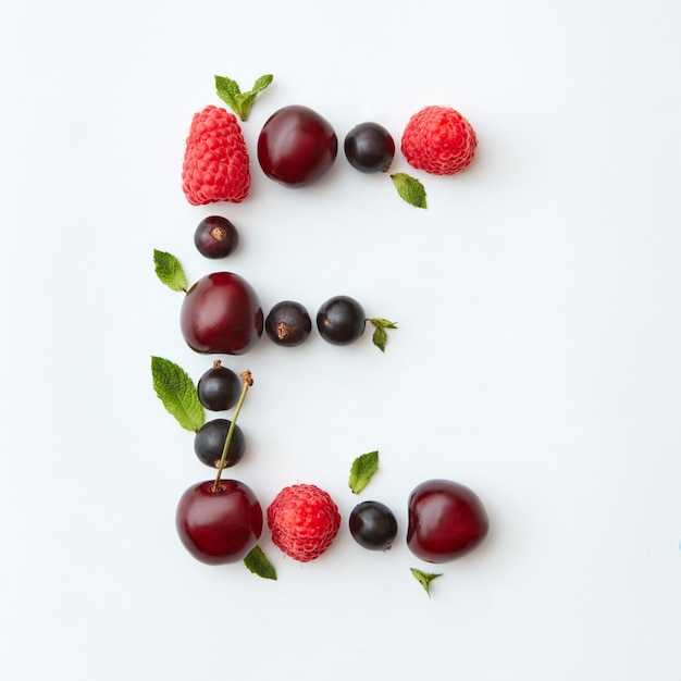 Świeże owoce wzór litery E alfabetu angielskiego z naturalnych dojrzałych jagód - czarna porzeczka