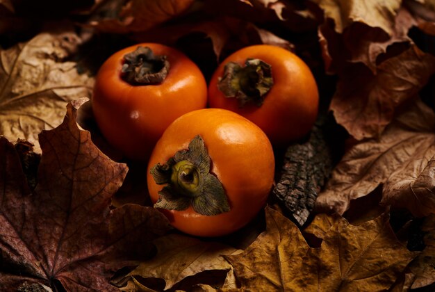 Świeże Persimmon Owoc W Pomarańczowych Jesień Liściach Na Drewnie