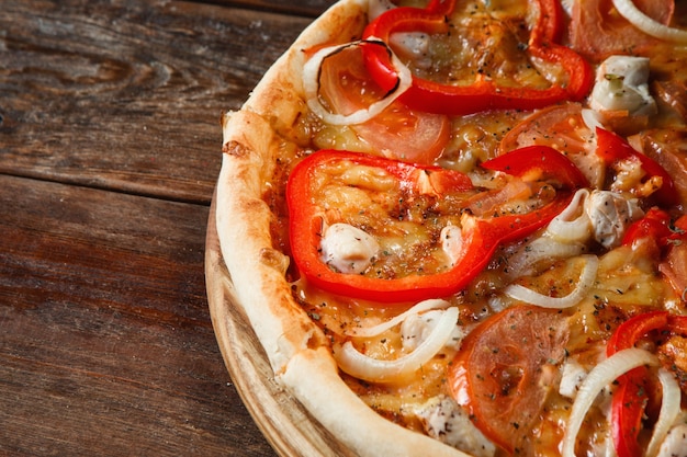 Świeże pieczone apetyczna kolorowa pizza na drewnianym stole w stylu rustykalnym, zbliżenie. Zdjęcie menu włoskiej restauracji, kuchnia tradycyjna.