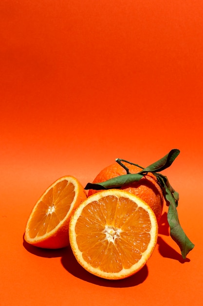 Świeże pomarańcze na pomarańczowym tle
